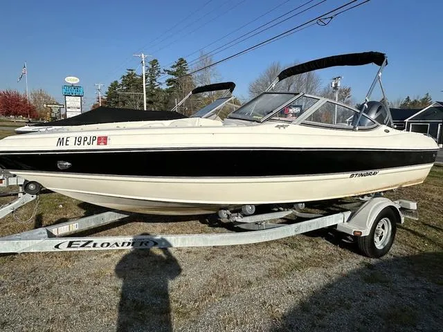 Slide: The Image of 2015 Stingray 191RX boat on trailer, parked outdoors, with black and white design. - 10