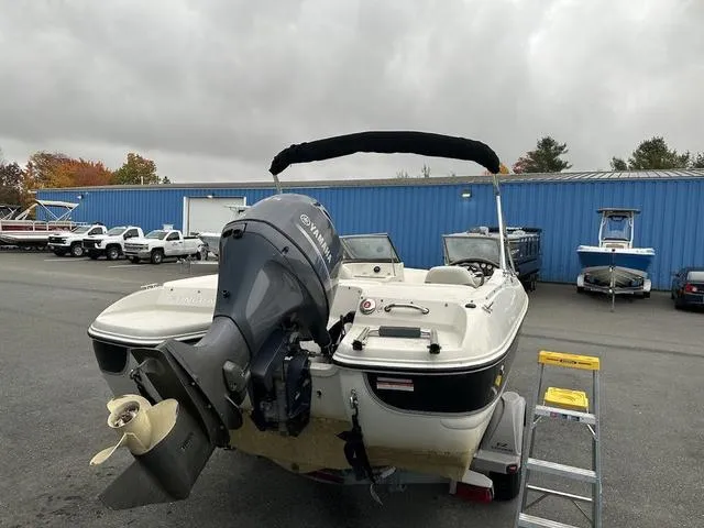 Slide: The Image of 2015 Stingray 191RX boat with Yamaha outboard motor, parked near blue building. - 5