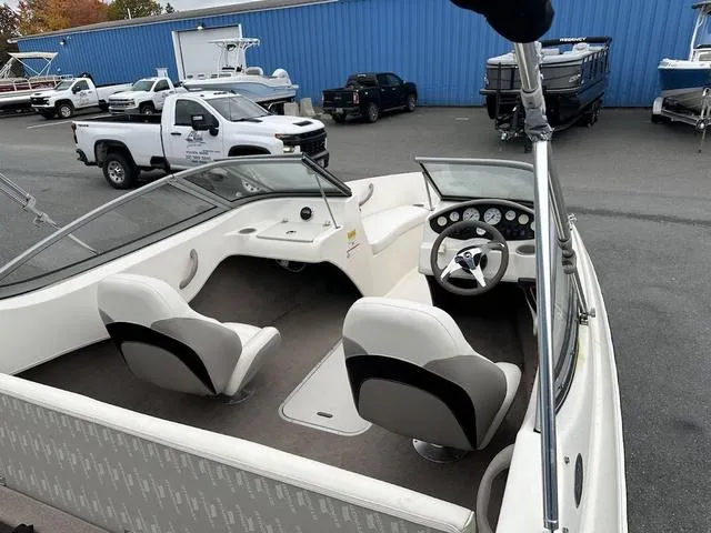Slide: The Image of 2015 Stingray 191RX boat interior with dual seats and dashboard, parked near trucks. - 7
