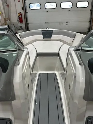 Slide: The Image of 2021 Chaparral 19 SSi boat interior with gray and white seating in a garage. - 10