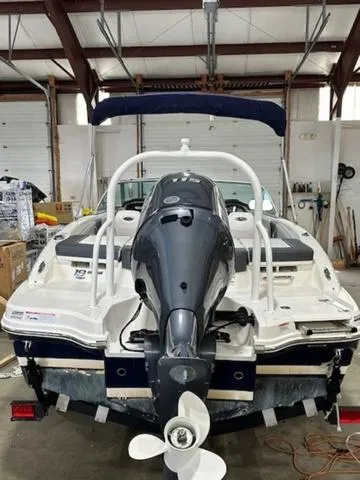Slide: The Image of 2021 Chaparral 19 SSi boat in a garage, rear view with outboard motor. - 3