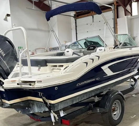 Slide: The Image of 2021 Chaparral 19 SSi boat in a garage, featuring a Yamaha outboard motor. - 5