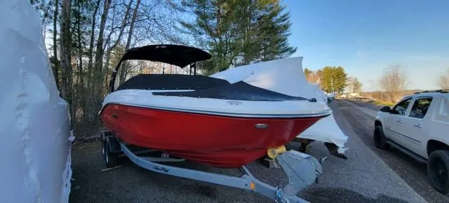 Slide: The Image of 2019 Sea Ray SPX 230 boat with red hull on trailer, parked outdoors. - 7