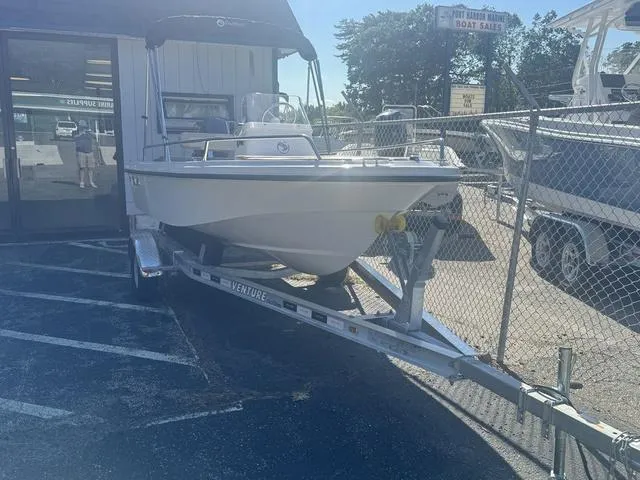 Slide: The Image of 2024 Edgewater 158CS boat on trailer outside a boat sales shop. - 12