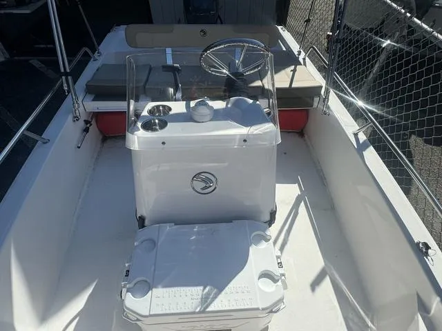 Slide: The Image of 2024 Edgewater 158CS boat interior with steering console and seating area. - 6