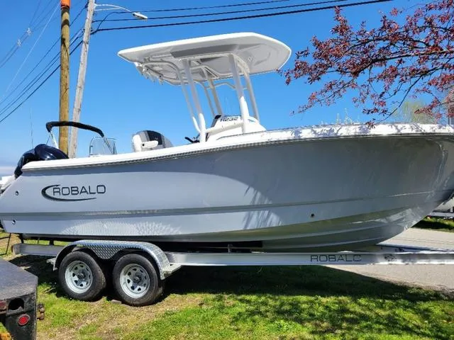 Slide: The Image of 2024 Robalo R232EX boat on trailer, side view, outdoors, sunny day. - 3