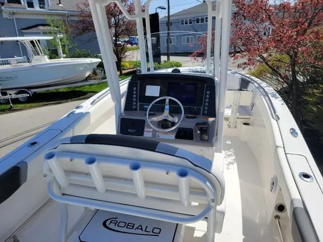 Slide: The Image of 2024 Robalo R232EX boat interior with steering console and seating. - 7