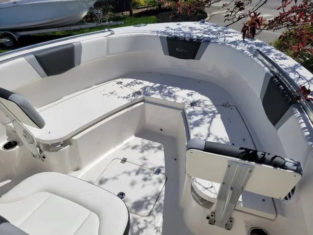 Slide: The Image of 2024 Robalo R232EX boat interior with white seating and storage compartments. - 9