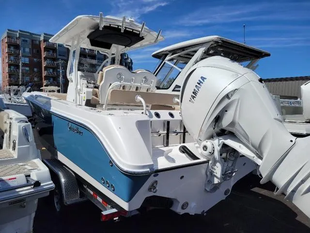Slide: The Image of 2024 Edgewater 245CC boat with Yamaha engine, docked in marina under clear blue sky. - 4