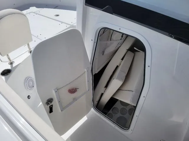 Slide: The Image of 2024 Sea Hunt Gamefish 25 boat interior storage compartment with open door. - 17