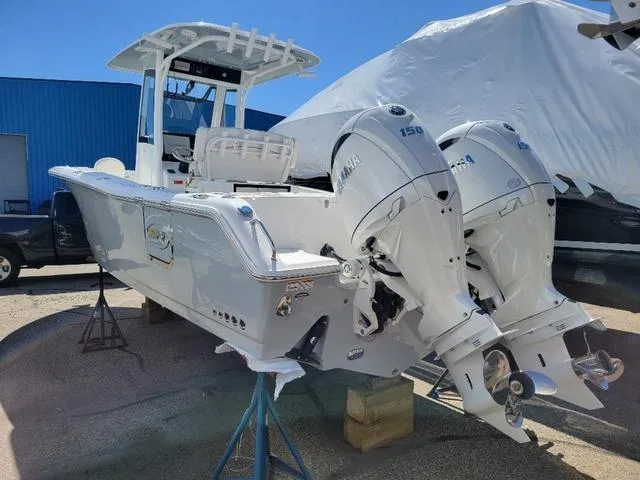 Slide: The Image of 2024 Sea Hunt Gamefish 25 boat with dual Yamaha 150 engines, docked outdoors. - 3