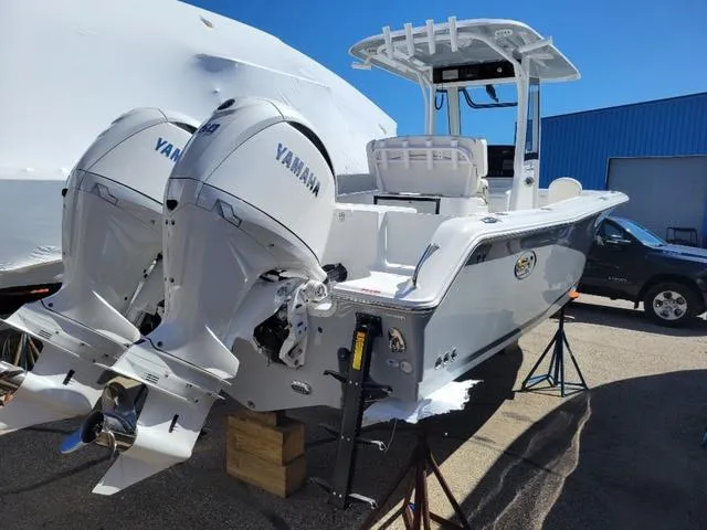 Slide: The Image of 2024 Sea Hunt Gamefish 25 boat with twin Yamaha engines, displayed outdoors. - 5