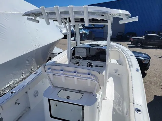Slide: The Image of 2024 Sea Hunt Gamefish 25 boat interior with console and seating, docked outdoors. - 7