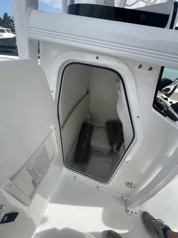 Slide: The Image of 2025 Sea Hunt Ultra 219 boat interior storage compartment with open door. - 13