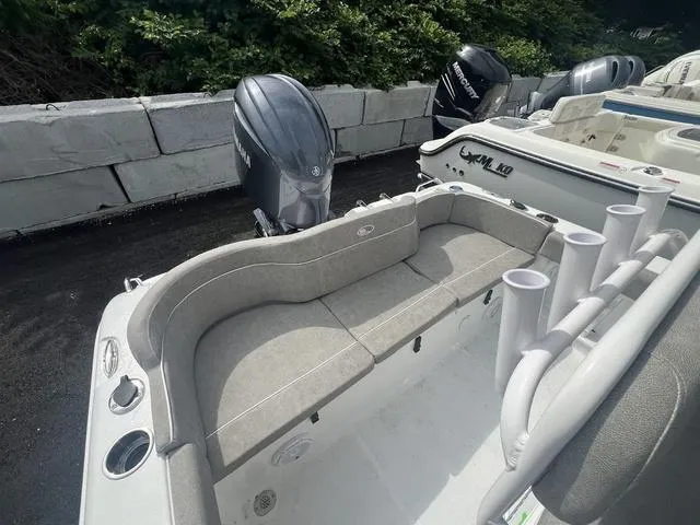 Slide: The Image of 2025 Sea Hunt Ultra 219 boat with seating and rod holders, docked outdoors. - 15