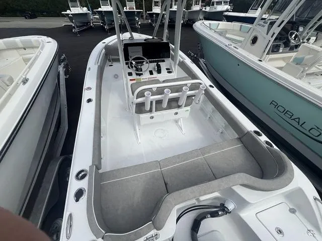 Slide: The Image of 2025 Sea Hunt Ultra 219 boat interior with seating and console, docked alongside other boats. - 20