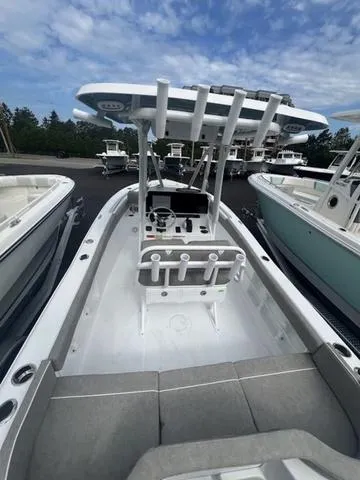 Slide: The Image of 2025 Sea Hunt Ultra 219 boat with center console, docked under a partly cloudy sky. - 21