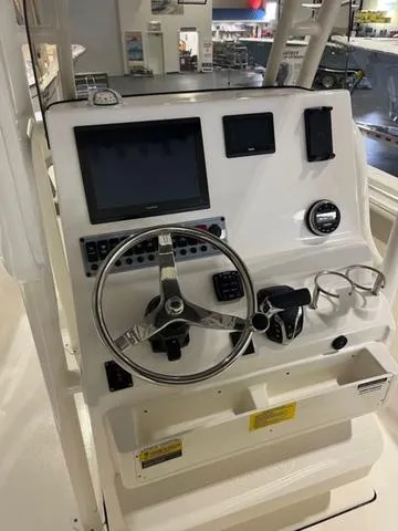 Slide: The Image of 2025 Key West 239 FS boat dashboard with steering wheel and electronic controls. - 6