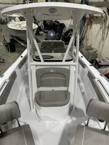 Slide: The Image of 2025 Sea Hunt Ultra 229 boat interior with seating and console in a workshop setting. - 14