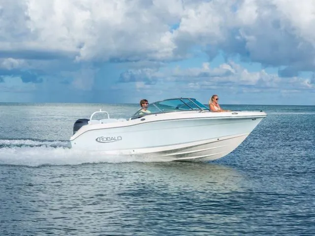 Slide: The Image of 2025 Robalo R207 boat cruising on open water under a cloudy sky. - 1