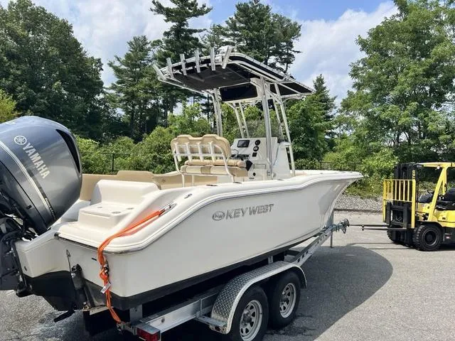Slide: The Image of 2019 Key West 239FS boat on trailer with Yamaha engine, surrounded by trees. - 4