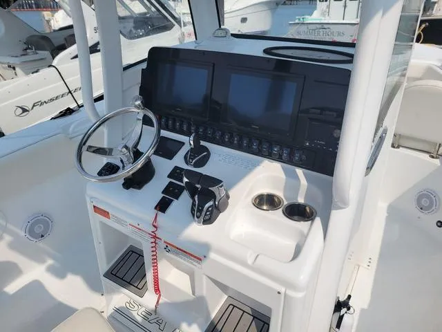 Slide: The Image of 2024 Sea Hunt Gamefish 27 helm with dual displays and modern controls. - 16