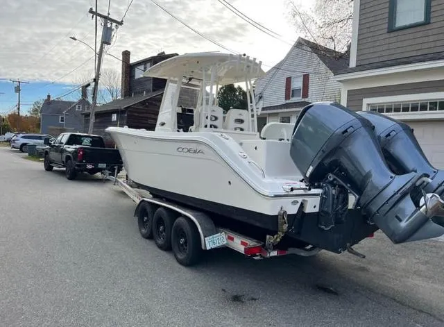 Slide: The Image of 2019 Cobia 301CC boat on trailer, parked on residential street. - 2