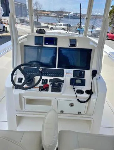 Slide: The Image of 2019 Cobia 301CC boat dashboard with dual screens and navigation controls. - 4