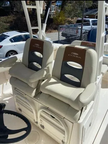 Slide: The Image of 2019 Cobia 301CC boat with dual cushioned seats and steering wheel. - 6