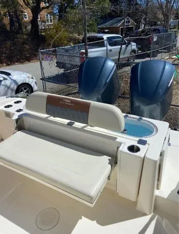 Slide: The Image of 2019 Cobia 301CC boat with dual engines and seating area, parked outdoors. - 8