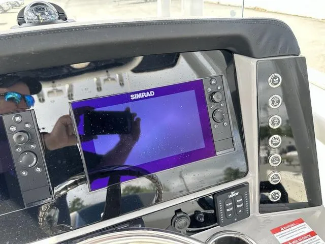 Slide: The Image of Simrad display on 2022 Robalo R242 boat dashboard with control buttons. - 12