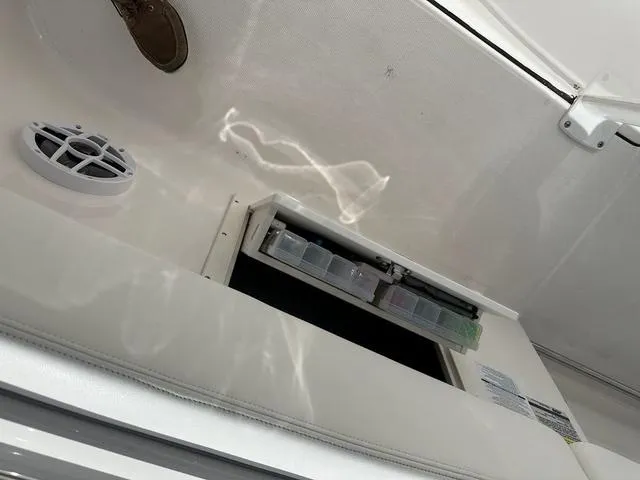 Slide: The Image of 2022 Robalo R242 boat interior with storage compartment and speaker. - 14