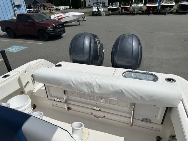Slide: The Image of 2022 Robalo R242 boat with dual outboard motors in a marina parking lot. - 21