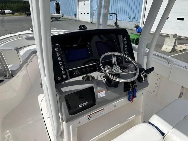Slide: The Image of 2022 Robalo R242 boat dashboard with steering wheel and electronic displays. - 22