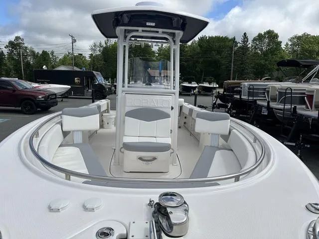 Slide: The Image of 2022 Robalo R242 boat with spacious seating and sleek design in a marina setting. - 4