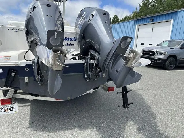 Slide: The Image of 2022 Robalo R242 boat with dual outboard motors in a parking lot. - 6