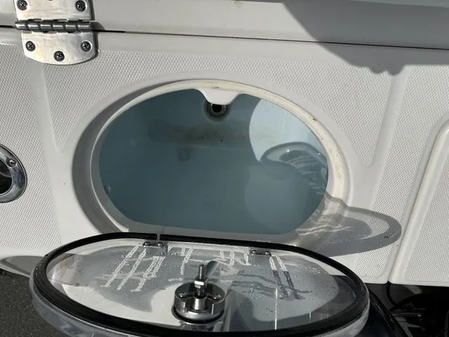 Slide: The Image of Livewell compartment on a 2022 Robalo R242 boat, featuring a clear lid and secure latch. - 9