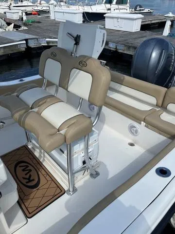 Slide: The Image of 2020 Key West 219fs boat interior with beige seating at a marina. - 6