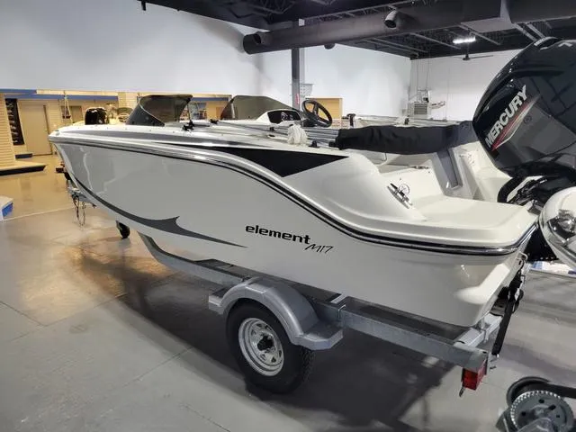 Slide: The Image of 2023 Bayliner Element M17 boat on display in showroom, featuring sleek design and Mercury engine. - 7