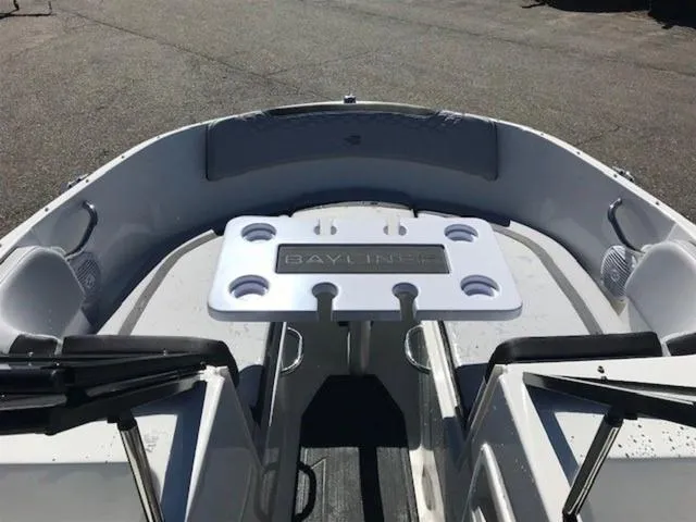 Slide: The Image of 2024 Bayliner M17 boat interior with seating and table, featuring cup holders. - 16