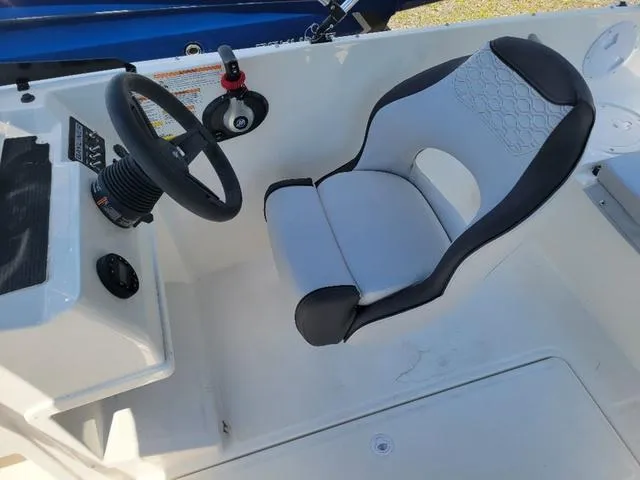 Slide: The Image of 2024 Bayliner M19 boat interior with steering wheel and cushioned seat. - 12