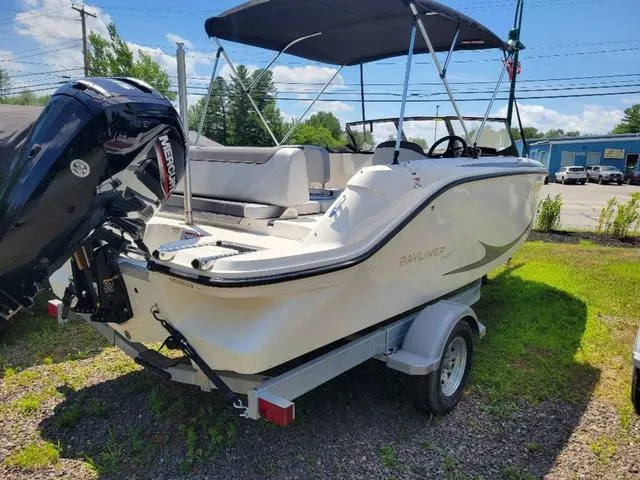 Slide: The Image of 2024 Bayliner M19 boat on trailer with Mercury outboard motor, parked outdoors. - 4