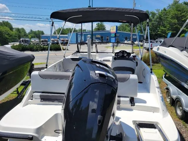Slide: The Image of 2024 Bayliner M19 boat with canopy and outboard motor, parked outdoors. - 5