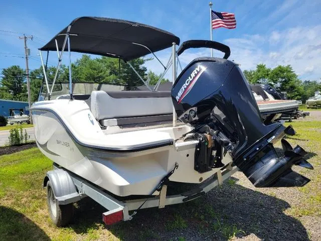 Slide: The Image of 2024 Bayliner M19 boat with Mercury outboard motor on trailer, under a clear blue sky. - 6