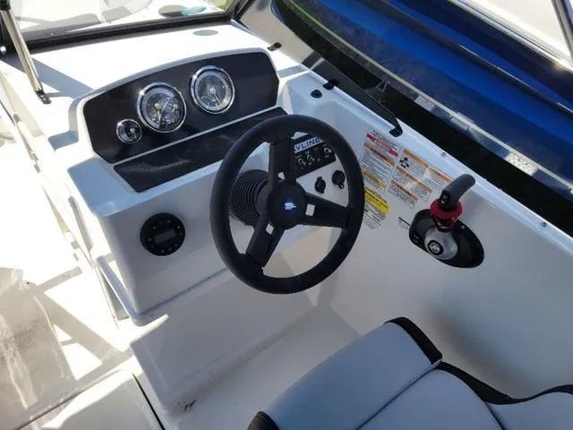 Slide: The Image of 2024 Bayliner M19 boat cockpit with steering wheel and instrument panel. - 8