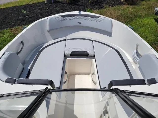 Slide: The Image of 2024 Bayliner M19 boat interior with cushioned seating and storage compartment. - 9