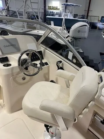 Slide: The Image of 2024 Grady-White Freedom 215 boat interior with steering wheel and Garmin display. - 11