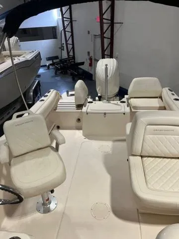 Slide: The Image of 2024 Grady-White Freedom 215 boat interior with cushioned seating and steering wheel. - 14