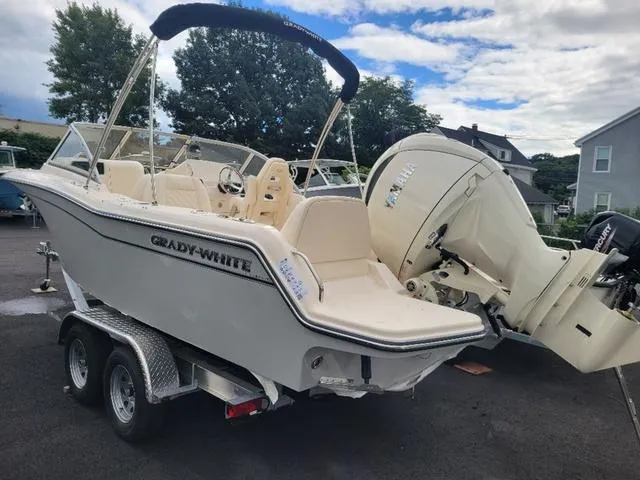 Slide: The Image of 2025 Grady-White Freedom 215 boat on trailer, parked outdoors under cloudy sky. - 6