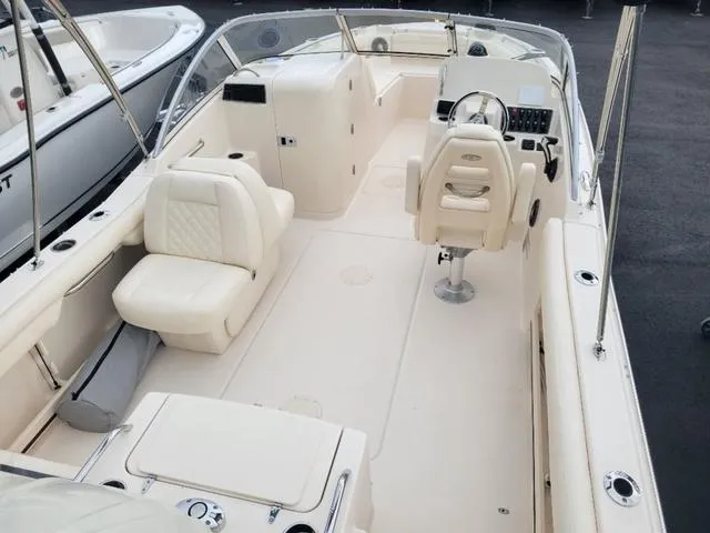 Slide: The Image of 2025 Grady-White Freedom 215 boat interior with cream seating and steering console. - 7